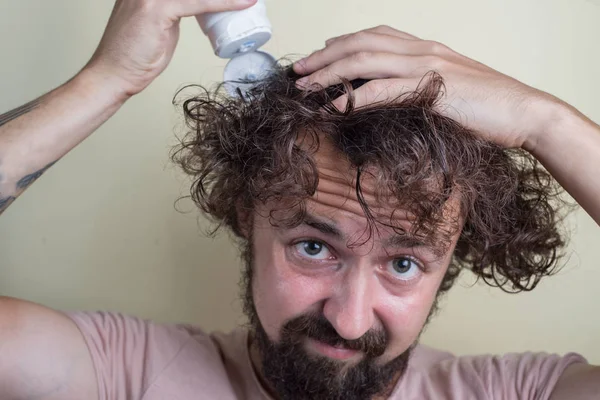 Retrato de um jovem, com o cabelo acima do peso, cabelo comprido. Despejar shampoo — Fotografia de Stock