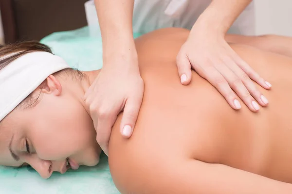 Masseur maakt massage aan een mooi meisje. Kuuroord plezier — Stockfoto