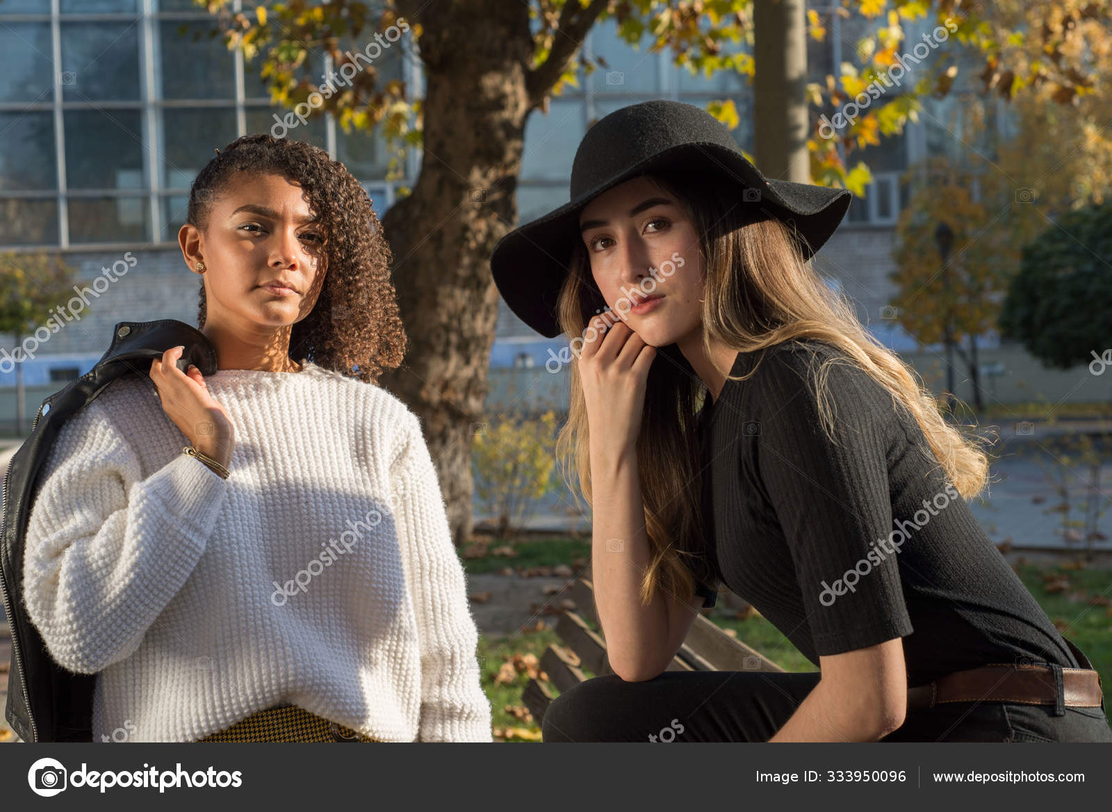 Retrato de dos hermosas chicas de la generación milenaria mexicana. Sesión  de fotos de otoño en el parque junto al banco .: fotografía de stock ©  alexstockphoto21 #333950096