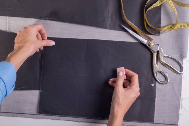 Elbise imalatı ve dikiminde bir ustanın el işçiliğinin en üst görüntüsü. Kalem ve cetvelle tasarımcı kız tasarımcı terzi elbiseleri için kumaş kesiminin sınırlarını belirler.