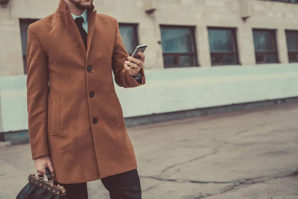 Portret van een jongeman van dertig. Zakenman in een zakelijke stijl van kleding. Rijdt in de passagiersstoel op kantoor om te werken, het oplossen van problemen op de smartphone, praten op de telefoon — Stockfoto