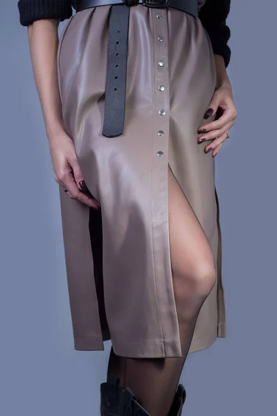 Catálogo publicidad foto de una joven pelirroja en un vestido de cuero beige de cuero de alta calidad, y un suéter negro. Sobre un fondo gris oscuro — Foto de Stock