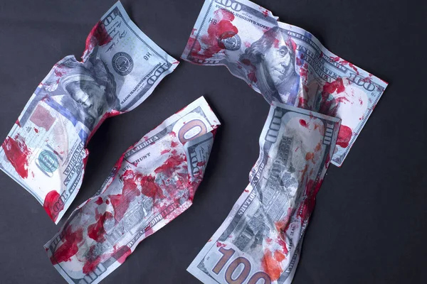 Yakın plan, kanlı, buruşuk dolar banknotları siyah arka planda yatıyor. Kavram