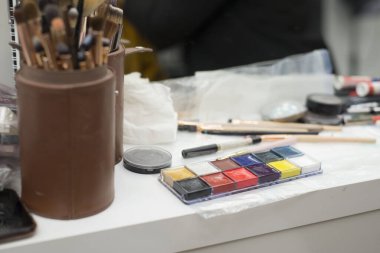 Bir çantadaki farklı fırçalar. Makyaj sanatçısı masaya resim çizer