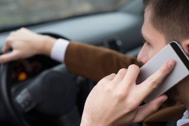 Otuz yaşında genç bir adamın portresi. İş adamı gibi giyinmiş bir iş adamı. Ofisteki yolcu koltuğunda çalışıyor, akıllı telefondaki sorunları çözüyor, telefonla konuşuyor.