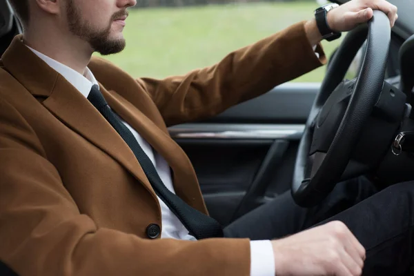 Retrato de un joven barbudo en un traje conduciendo un coche —  Fotos de Stock