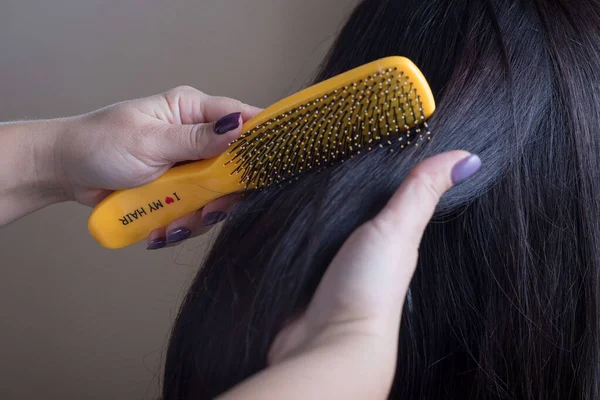 Închiderea unui coafor pieptănându-și părul cu un pieptene galben cu numele Îmi place părul meu . — Fotografie, imagine de stoc