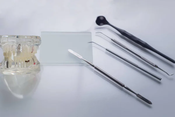 Vista superior, instrumentos dentários médicos, em uma mesa de assunto estéril de um médico dentista. Perto do manequim de mandíbulas e dentes humanos. Flatlay médico — Fotografia de Stock