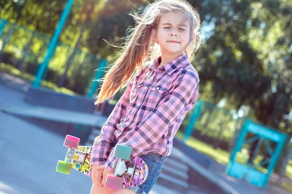 Retrato de uma adolescente, segurando skate, olhando para baixo. estilo de vida ativo de uma criança — Fotografia de Stock