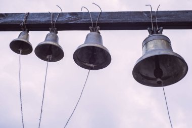 Kilise çanı, bahçede, gökyüzüne karşı.