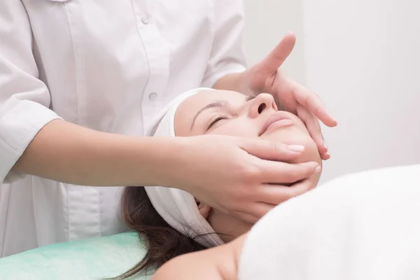 Massageterapeut Utför Ansiktsmassage Med Vacker Kvinna Händerna Närmar Sig Massagerum — Stockfoto
