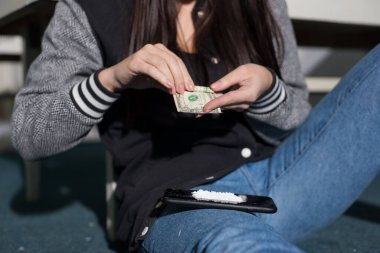 Kokain tozu ve pipet kullanan genç bir kokain kızının portresi. Kadınlarda uyuşturucu kullanımı sorunu. Sokak uyuşturucu kullanımı. Alışkanlık, uyuşturucu bağımlılığı, şeytani tozlar.