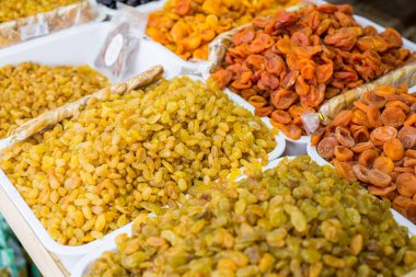 Mağaza tezgahının genel planı çeşitli kurutulmuş meyvelerin satışıyla birlikte. Yüksek kalorili kuru meyveler. Meyveler, kurutulmuş şeftali, incir, kayısı, kuru üzüm, kurutulmuş kayısı.