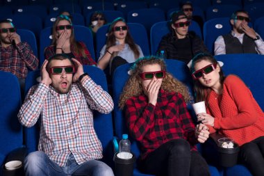 On dokuz ila otuz yaş arası farklı cinsiyetlerden gençlerin genel planı. Sinema salonunda korku filmi seyreden insanların duyguları. Z Jenerasyonu, Y Jenerasyonu, Millennials. Film izlemeden önce dinlenmek, film izlerken dinlenmek,