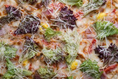 İnce dilimlenmiş pepperoni, Amerikan usulü pizzacılarda popüler bir pizza çeşididir. Bir tepside yakın plan pizza, sebze ve etle birlikte, kırsal bir tarzda. Olağandışı bir açı. Salata, sebzeli pizza, et yemeği. Dost canlısı pizza. Pizzanın dokusu. Yiyecekler. Ba