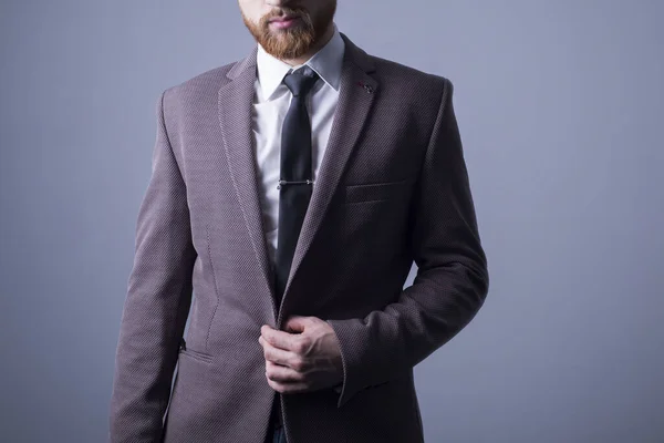양복을 수염을 잘생긴 남자의 스튜디오 재킷에 버튼을 누릅니다 질문을 받았다 — 스톡 사진