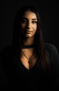 20 yaşında, sanatsal rötuşların sıcacık renklerinde genç güzel bir kızın stüdyo portresi Mona Lisa 'nın eski, antik, pitoresk portrelerinin arka planına karşı. Kontrastlı kadın portresi. Siyah taşralı güzel bir kız