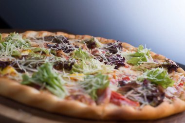 İnce dilimlenmiş pepperoni, Amerikan usulü pizzacılarda popüler bir pizza çeşididir. Bir tepside yakın plan pizza, sebze ve etle birlikte, kırsal bir tarzda. Olağandışı bir açı. Salata, sebzeli pizza, et yemeği. Dost canlısı pizza. Pizzanın dokusu. Yiyecekler. Ba