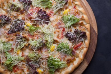 İnce dilimlenmiş pepperoni, Amerikan usulü pizzacılarda popüler bir pizza çeşididir. Bir tepside yakın plan pizza, sebze ve etle birlikte, kırsal bir tarzda. Olağandışı bir açı. Salata, sebzeli pizza, et yemeği. Dost canlısı pizza. Pizzanın dokusu. Yiyecekler. Ba