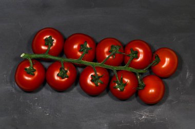 Siyah arkaplanda kırmızı domatesler. Sulu parlak renkler. Sebzeler.