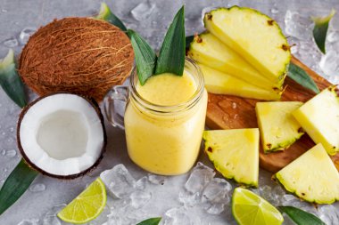 Sağlıklı olgun sarı ananas, Hindistan cevizi, dilim limon ve buz ile güler yüzlü