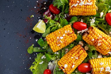 Lezzetli fırında Mısır pişmiş beyaz peynir, kırmızı biber, limon, sebze ile.