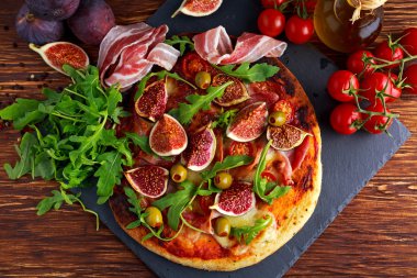 İncir pizza domuz pastırması, yeşil biberli zeytin, roket ve fesleğen yaprakları