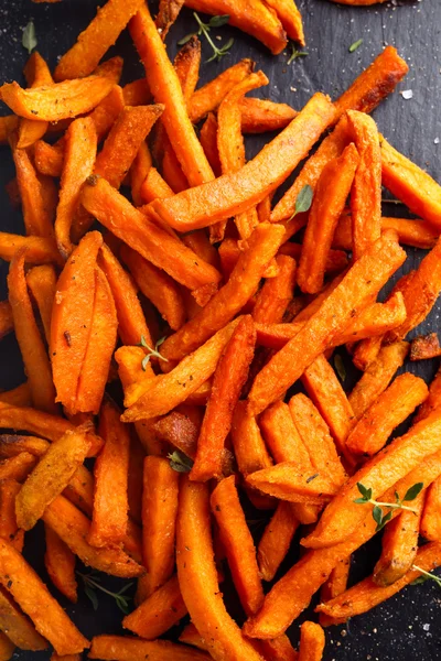 Sağlıklı ev yapımı pişmiş turuncu tatlı patates kızartması ile taze krema sosu, otlar, tuz ve biber daldırma. — Stok fotoğraf