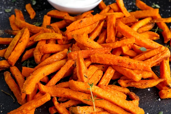 Hälsosam hemlagad bakade Orange Batat frites med färsk grädde doppa källkod, örter, salt och peppar. — Stockfoto