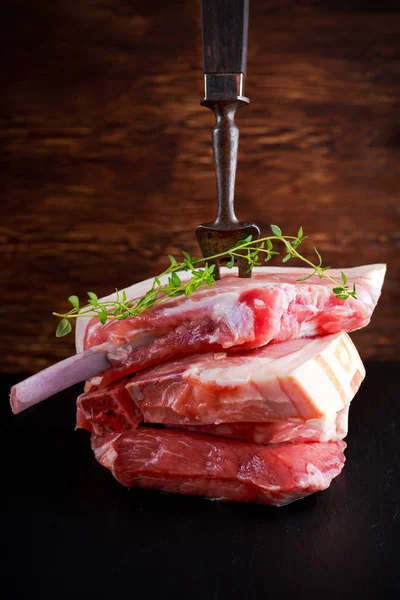 Costeletas de porco cru esfaqueadas com bife velho garfo — Fotografia de Stock