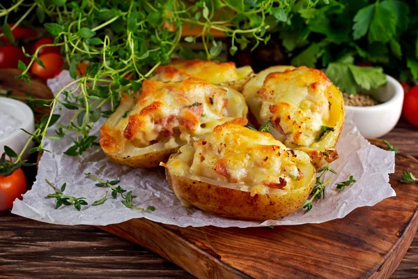 Batata recheada cozida quente com queijo, bacon, salsa na mesa de madeira . — Fotografia de Stock