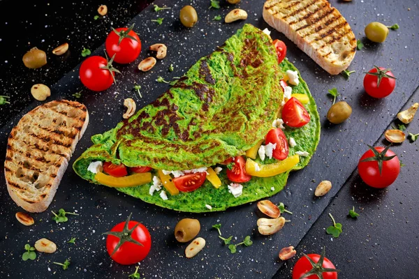 Verduras Omelete verde com tomates, queijo grego, azeitonas, nozes, páprica, torrada em fundo de pedra. conceito alimentos saudáveis . — Fotografia de Stock