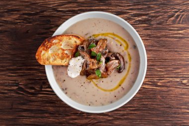 Kızarmış ekmek parçaları ve ekşi krema, zeytinyağı ile mantar çorbası