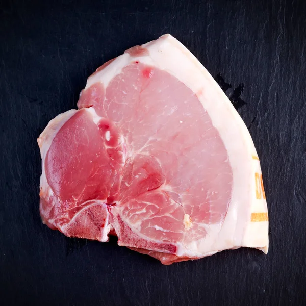 Von oben rohe Schweinekoteletts Steak T-bones auf Steinhintergrund — Stockfoto