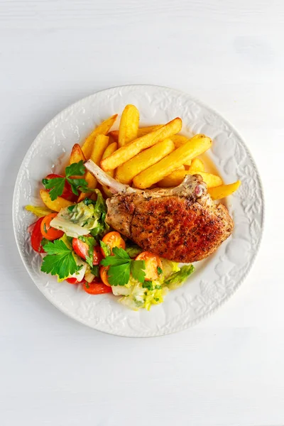 Grillezett sertés szelet hús körítve burgonya és saláta a fekete asztal — Stock Fotó