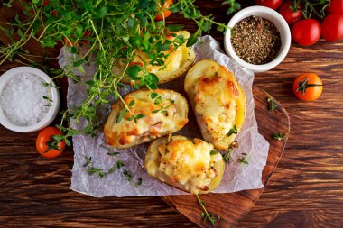 Sıcak Baked patates dolması ile peynir, pastırma, ahşap masa üzerine maydanoz.