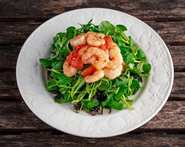 Taze sağlıklı karides pirinç salatası beyaz plaka üzerinde siyah