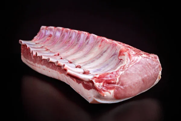 Fresh Raw French whole rack of pork loin with ribs on black board. — Stock Photo, Image