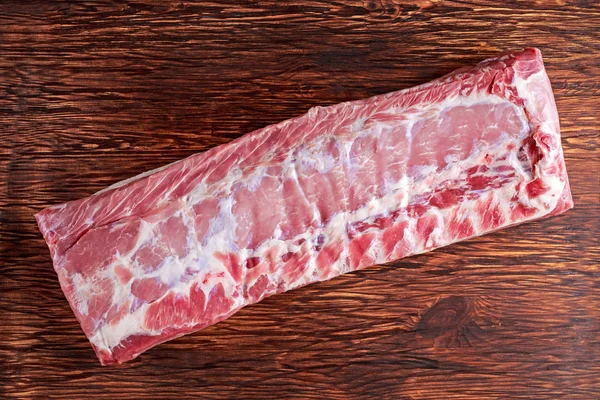 Viande fraîche entière de porc sans croûte sur planche de bois . — Photo