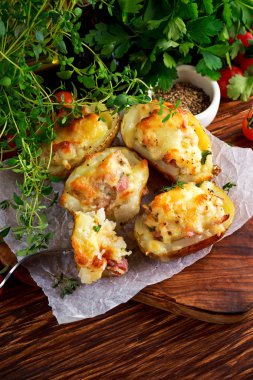 Sıcak Baked patates dolması ile peynir, pastırma, ahşap masa üzerine maydanoz.