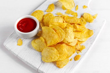 Altın ve beyaz tahta üzerinde sıcak soslu çıtır patates cipsi arka plan.