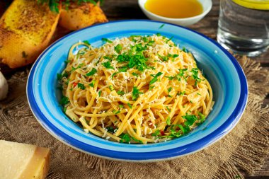 Vejetaryen İtalyan makarna spagetti Aglio E Olio sarımsaklı ekmek, kırmızı biber pul, maydanoz, parmesan peyniri ve glas su ile