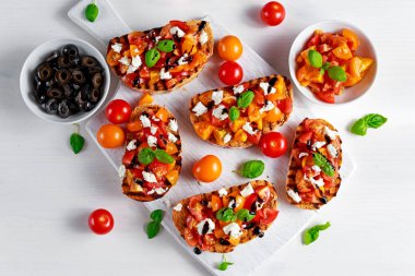 Beyaz peynir tepesi, taze fesleğen ve balsamik sirke ile lezzetli geleneksel domates bruschetta