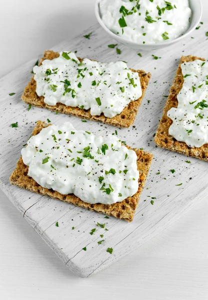 Tostadas caseras de pan crujiente con queso Cottage y perejil sobre tabla de madera blanca . —  Fotos de Stock