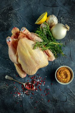 Tüm çiğ tavuk yemek pişirmek için malzemelerle. taş zemin üzerine