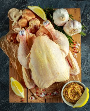 Tüm çiğ tavuk yemek pişirmek için malzemelerle. taş zemin üzerine