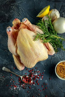 Tüm çiğ tavuk yemek pişirmek için malzemelerle. taş zemin üzerine