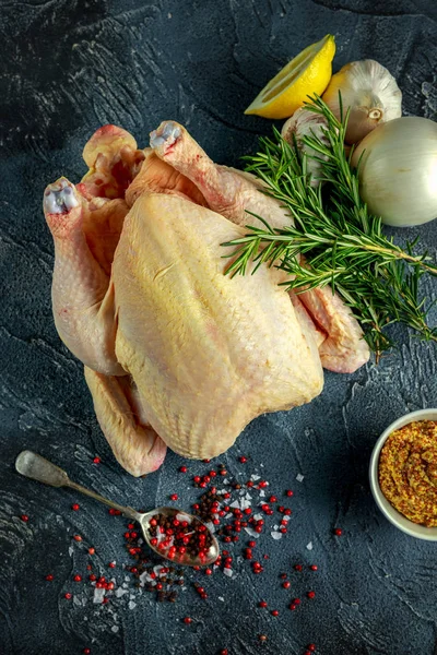 Tüm çiğ tavuk yemek pişirmek için malzemelerle. taş zemin üzerine