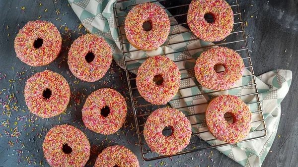 Iced doughnut rings with rainbow sparkl strands. — Stock Photo, Image