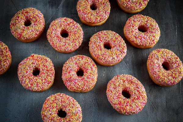 Iced doughnut rings with rainbow sparkl strands. — Stock Photo, Image